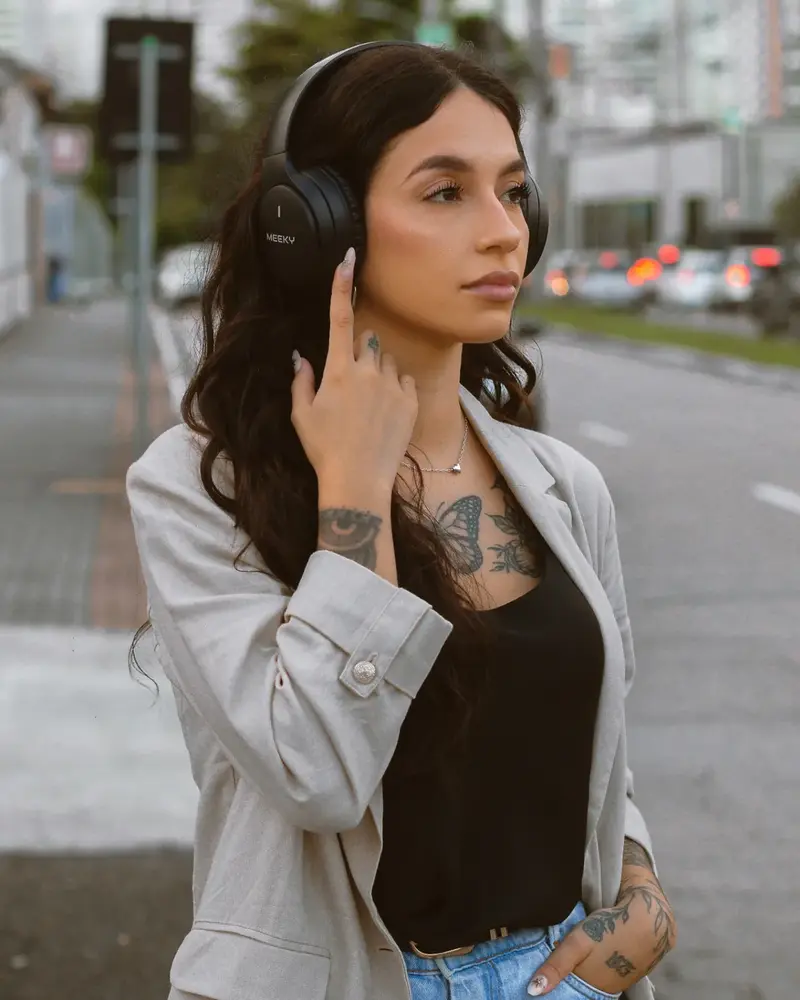 Modelo usando controle touch do fone Meeky F5 ANC Pro na rua